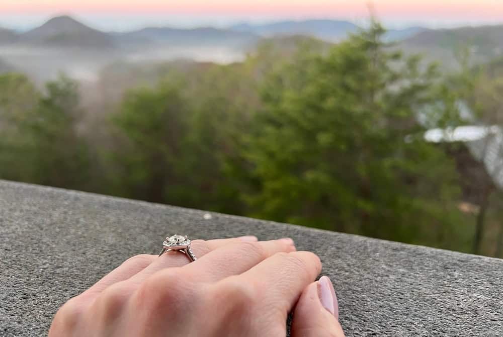 woman's hand with engagement ring in front of Smoky Mountain view